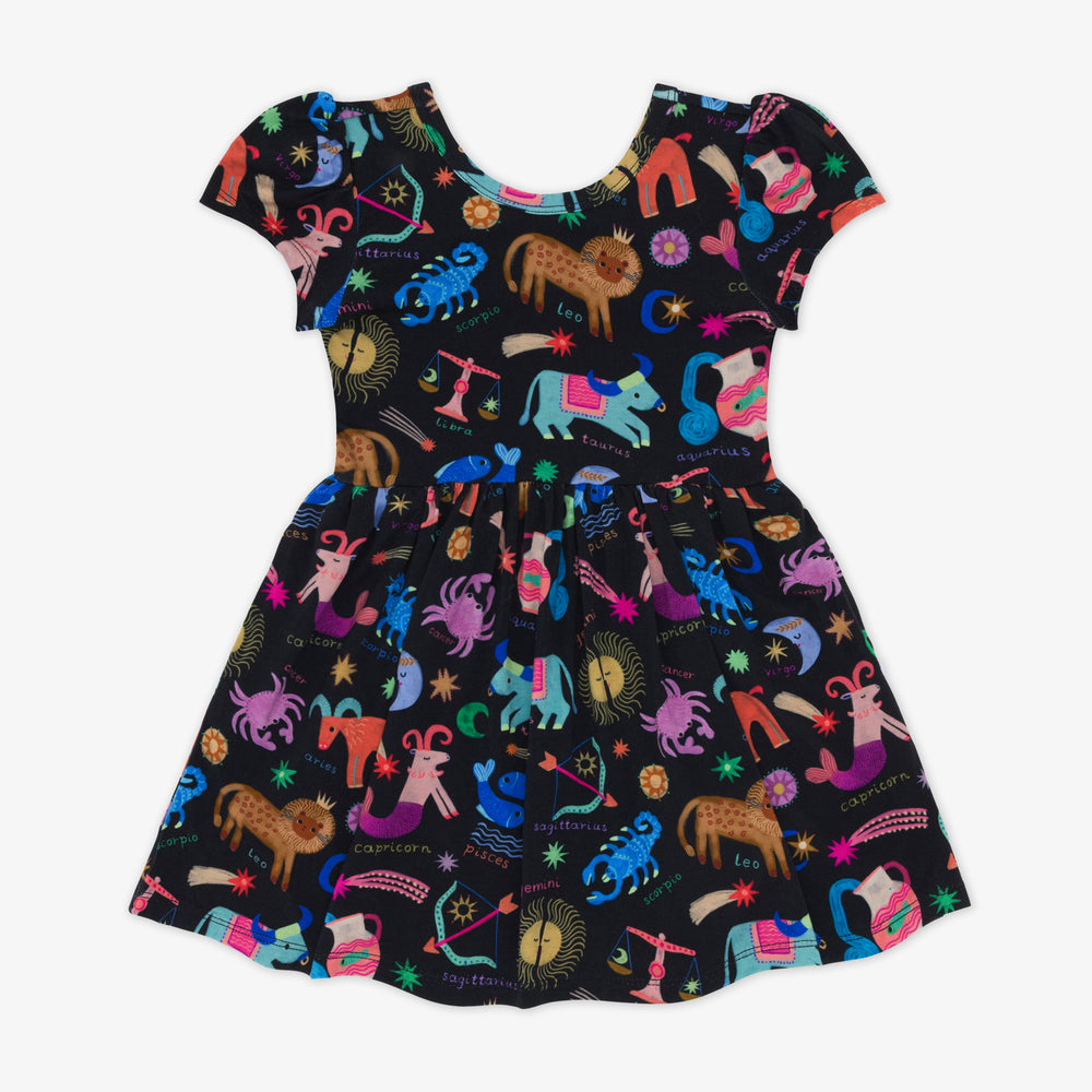 Flat lay of a star signs skater dress featuring multicolored drawings of the zodiac signs on a black background