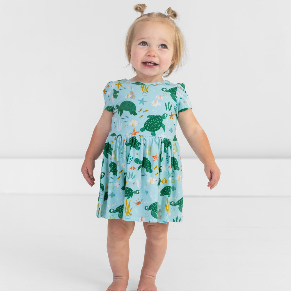 Image of a child wearing a Sea Turtle Friends Skater Dress with Bodysuit