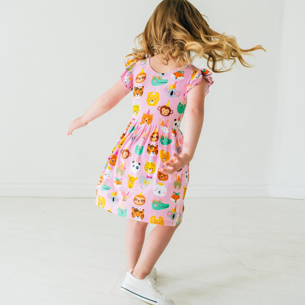Child twirling wearing a Pink Party Animals flutter skater dress