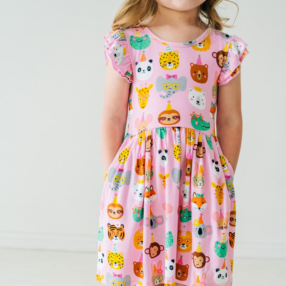 Close up image of a child wearing a Pink Party Animals flutter skater dress