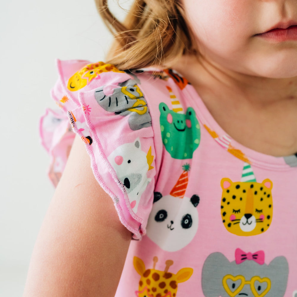 Close up image of a child wearing a Pink Party Animals flutter skater dress detailing the flutter sleeve