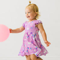 Child playing wearing a Magical Birthday flutter twirl dress with bodysuit