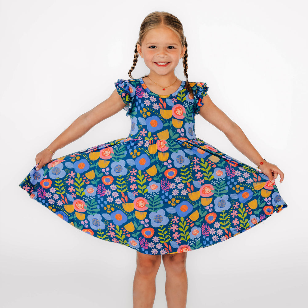 Girl posing while wearing the Folk Floral Flutter Twirl Dress