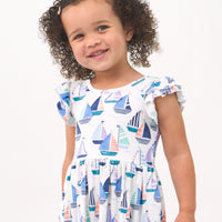 Close up image of a child wearing a Seas the Day flutter Skater Dress
