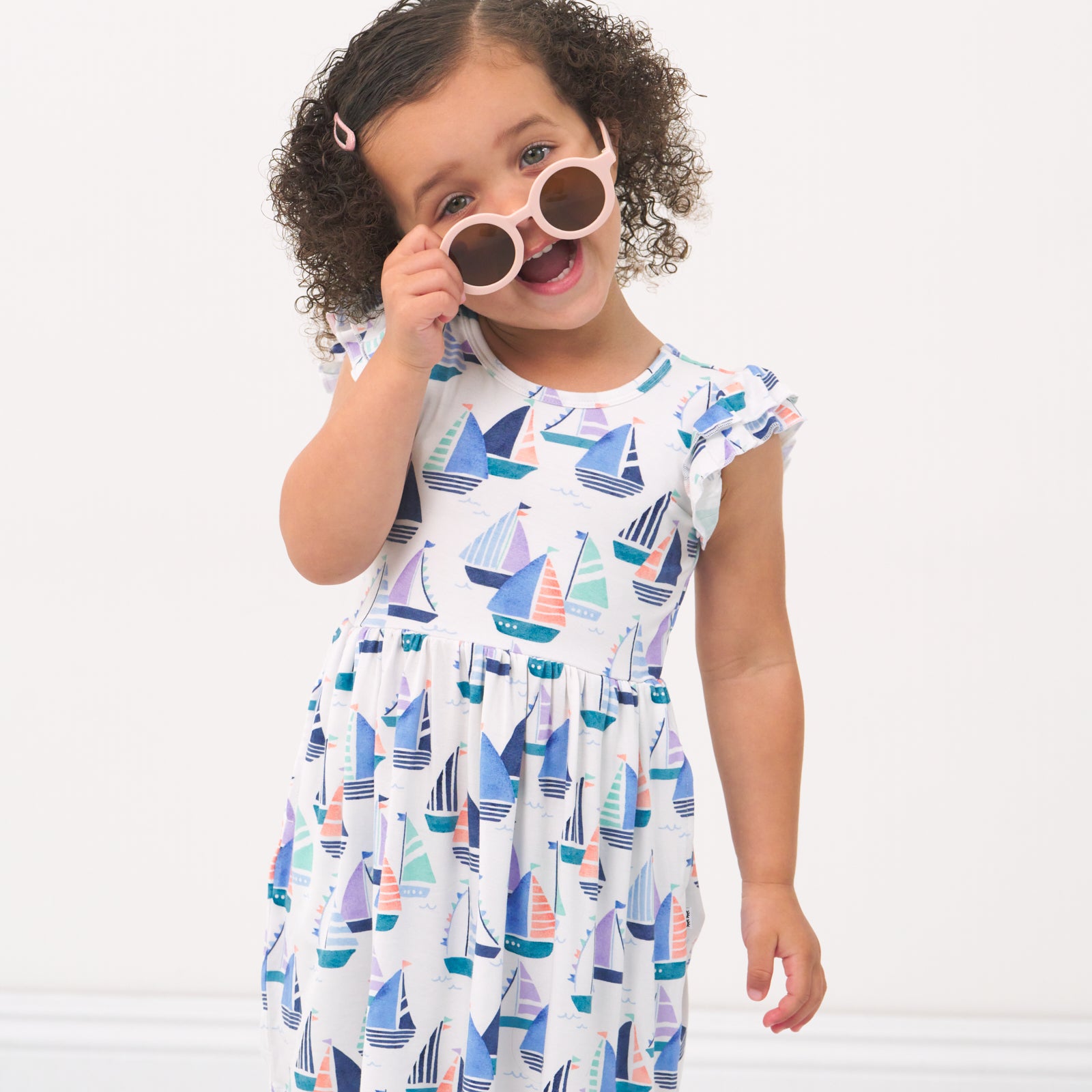 Child posing with sunglasses wearing a Seas the Day flutter Skater Dress