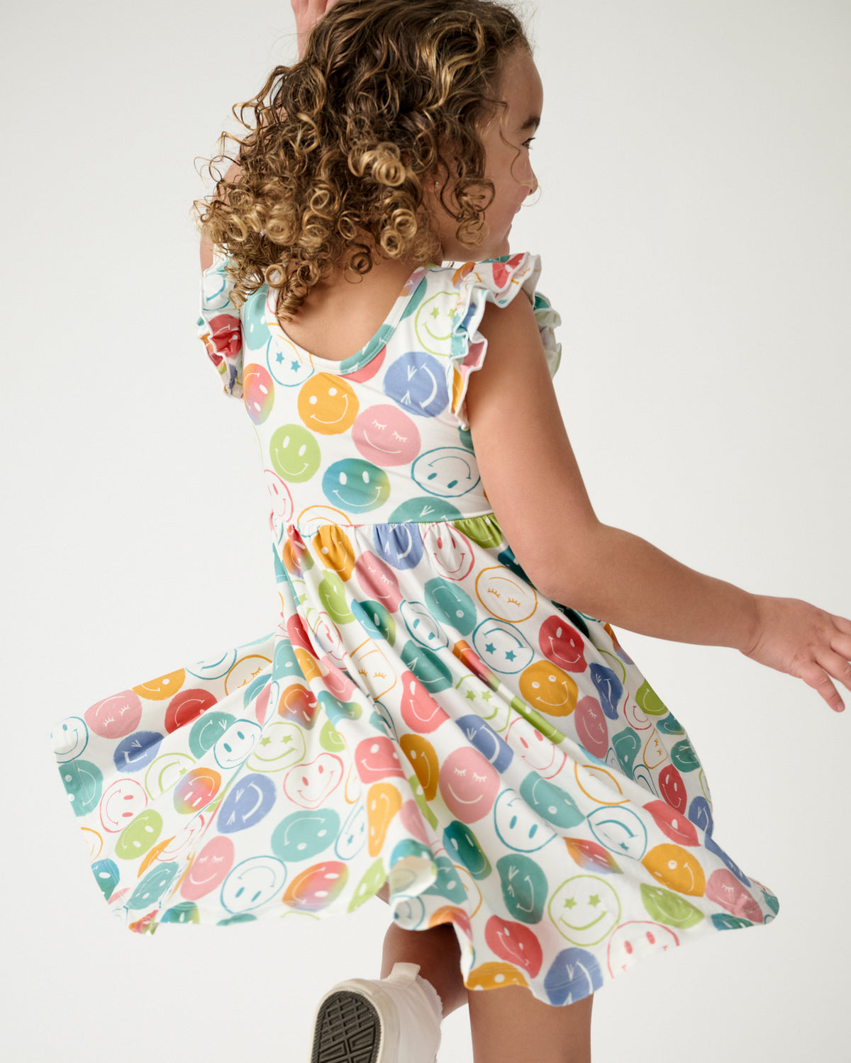Child in motion wearing the Positive Vibes Flutter Twirl Dress