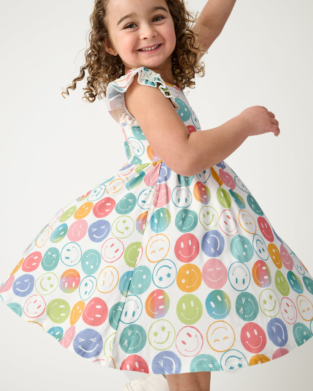 Child in motion wearing the Positive Vibes Flutter Twirl Dress