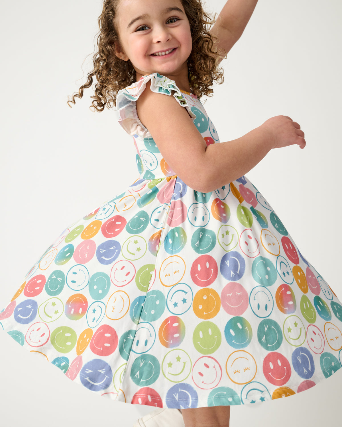 Child in motion wearing the Positive Vibes Flutter Twirl Dress