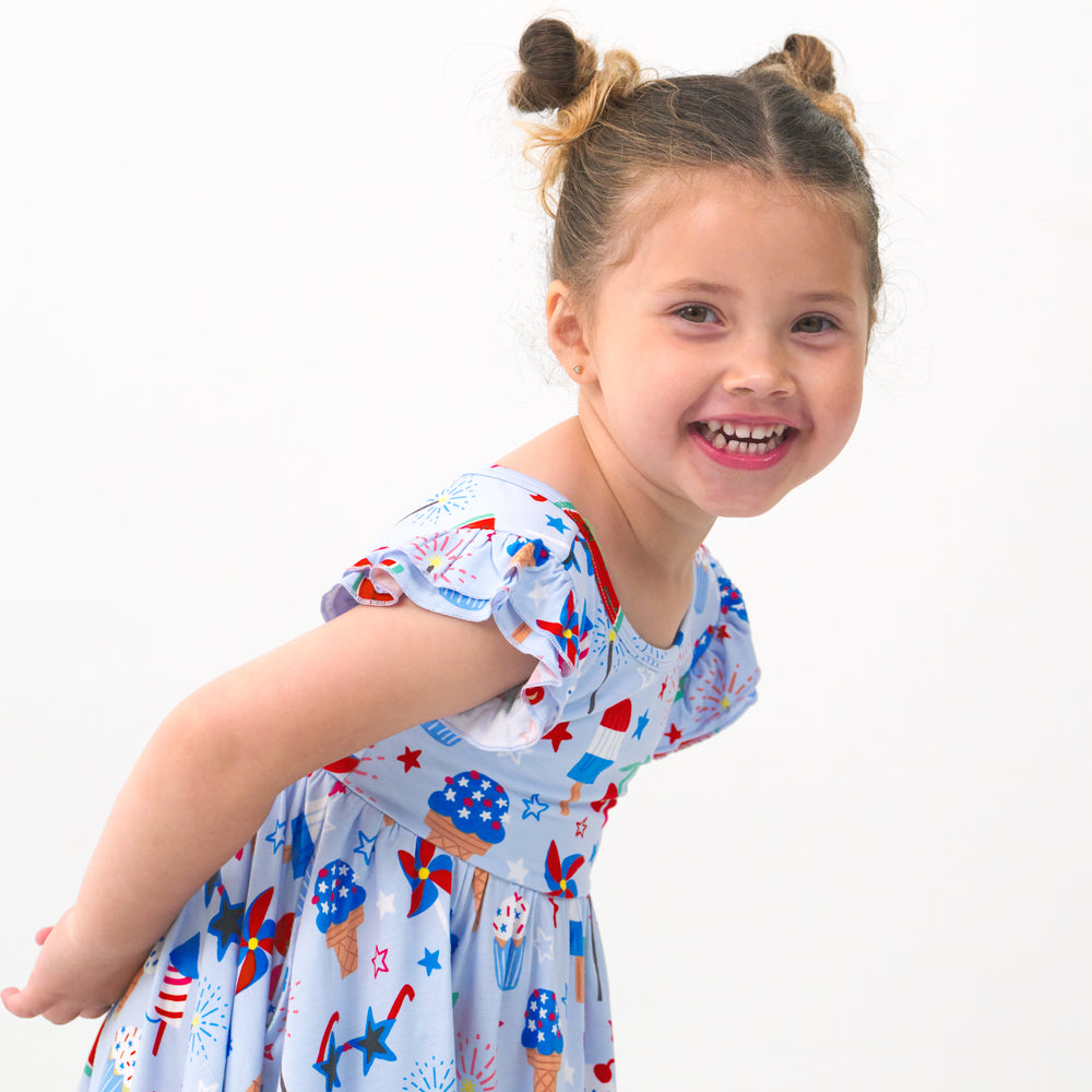 Close up image of a child wearing a Stars, Stripes & Sweets flutter twirl dress