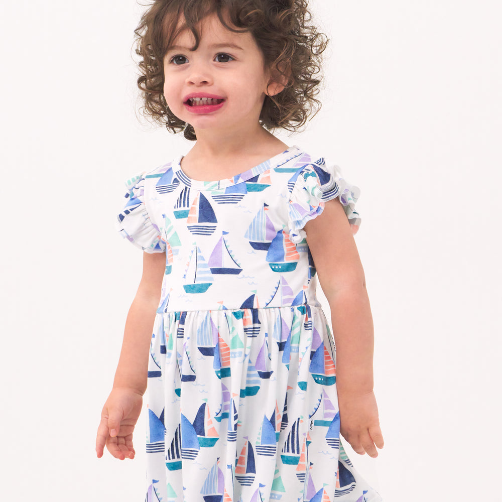 Close up image of a child wearing Seas the Day flutter skater dress with bodysuit