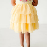 Close up image of a child wearing a Belle flutter tiered tutu dress