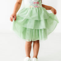 Close up image of a child wearing a Tiana flutter tiered tutu dress