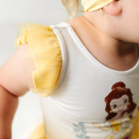 Close up image of a child wearing a Belle flutter tiered tutu dress with bloomer, detailing the flutter sleeve