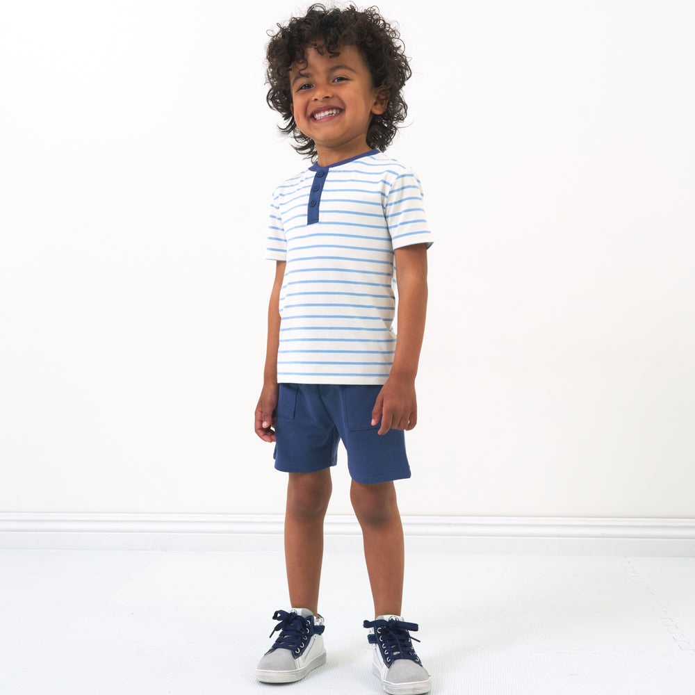 Child wearing Blue Wave Stripes Henley Tee paired with Vintage Navy shorts