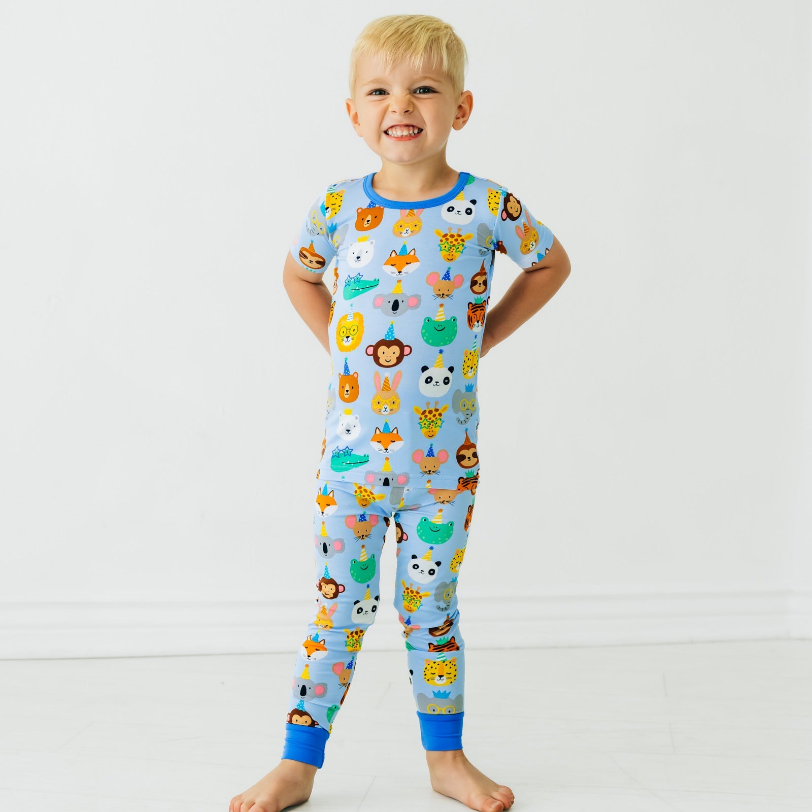 Child posing wearing a Blue Party Pals two piece short sleeve pj set