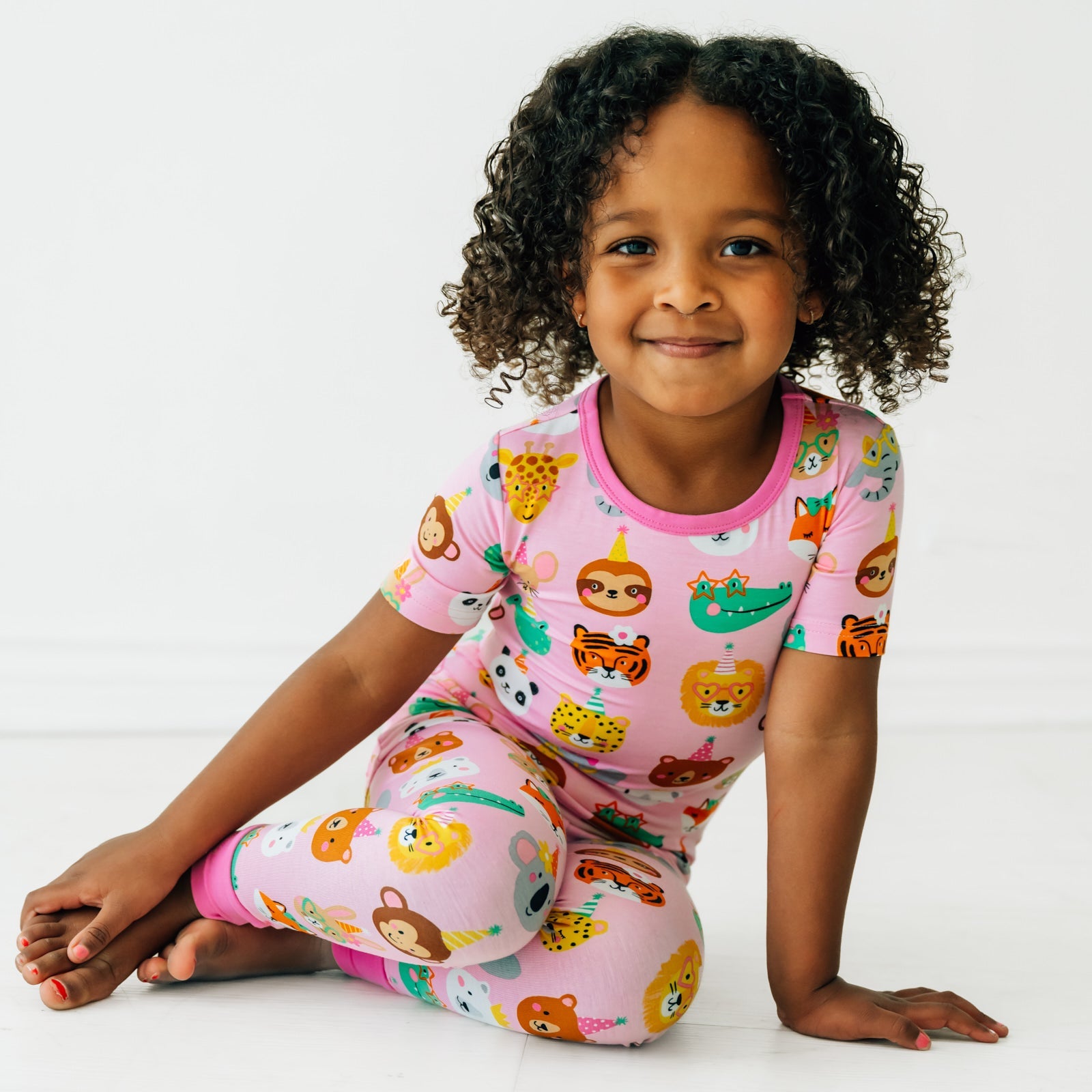 Child sitting wearing Pink Party Pals two piece short sleeve pj set