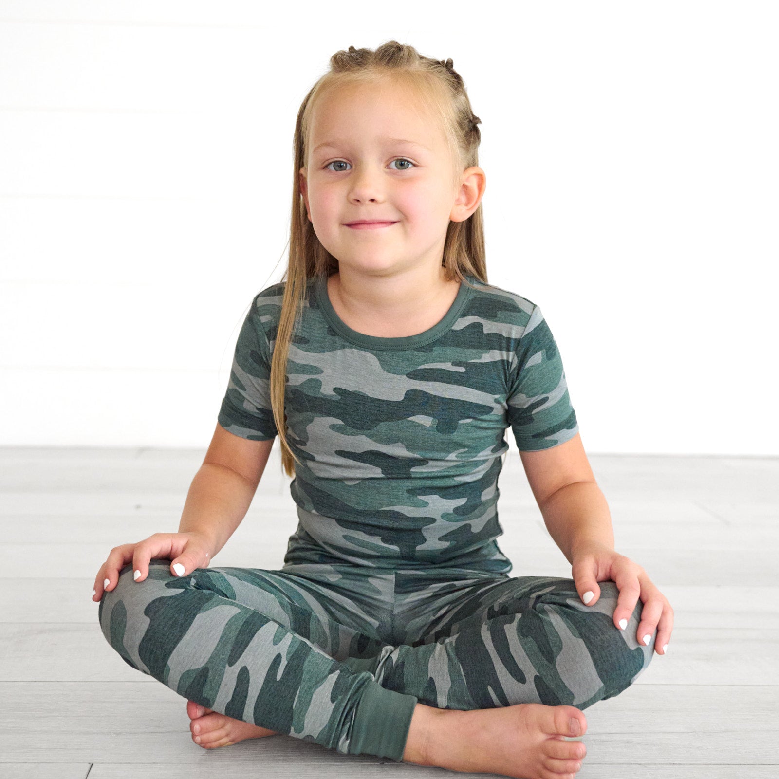 Girl sitting while in the Vintage Camo Two-Piece Short Sleeve Pajama Set