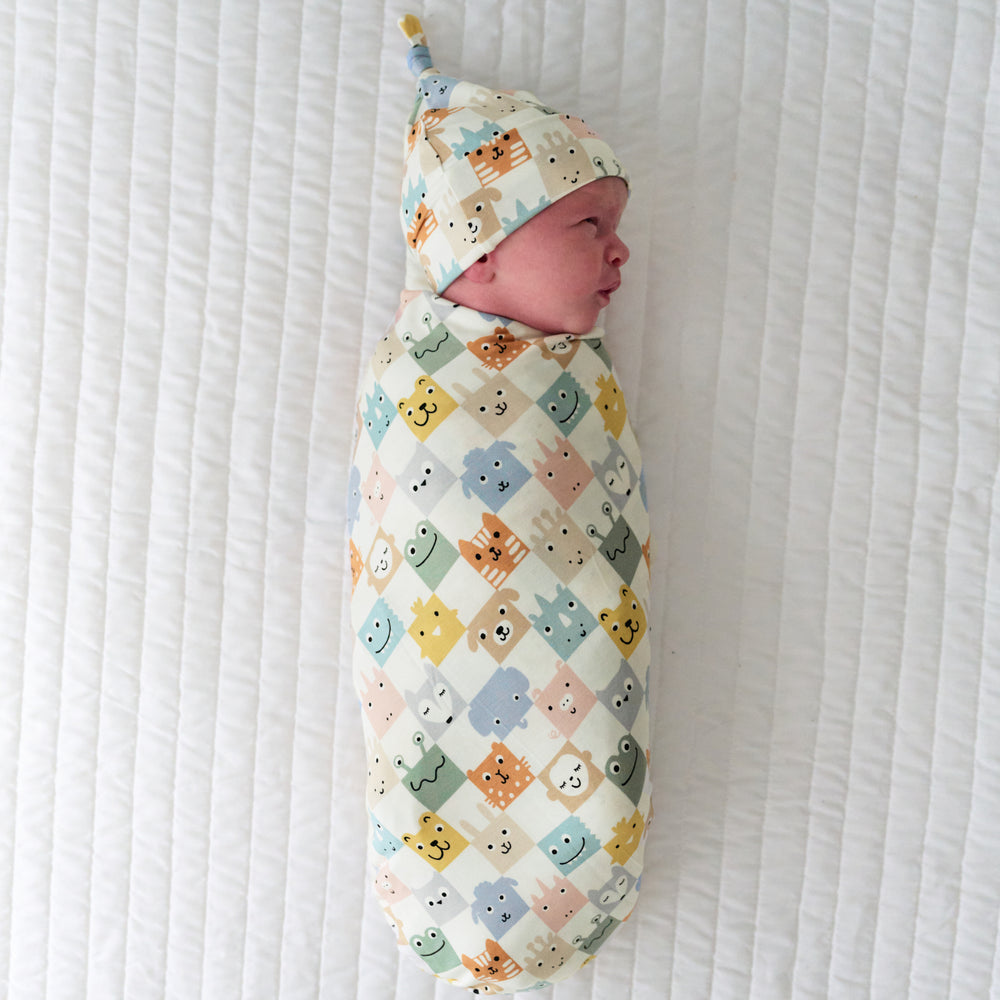 Infant swaddled in a Check Mates swaddle and hat set