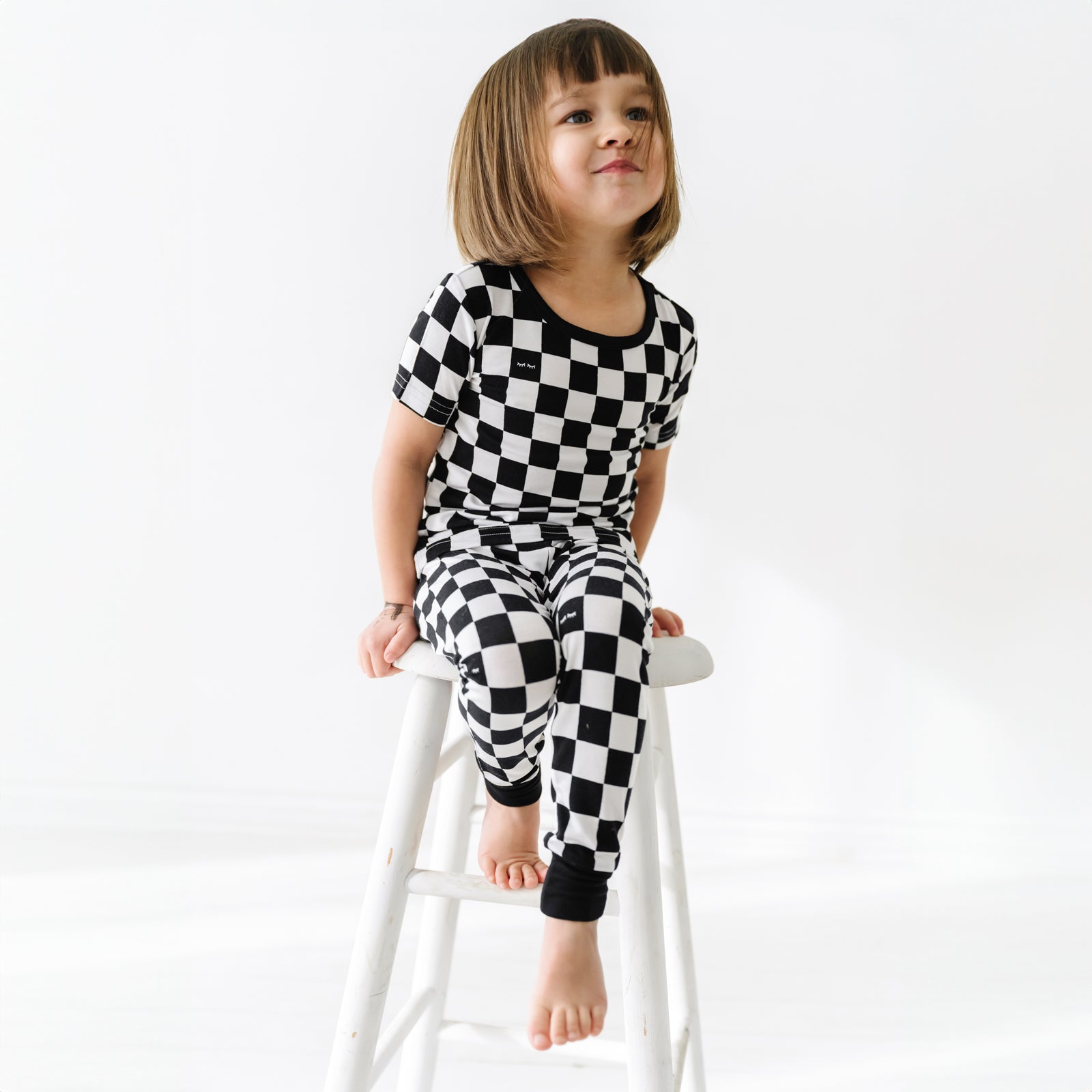 child sitting on a stool wearing Cool Checks short sleeve pj set