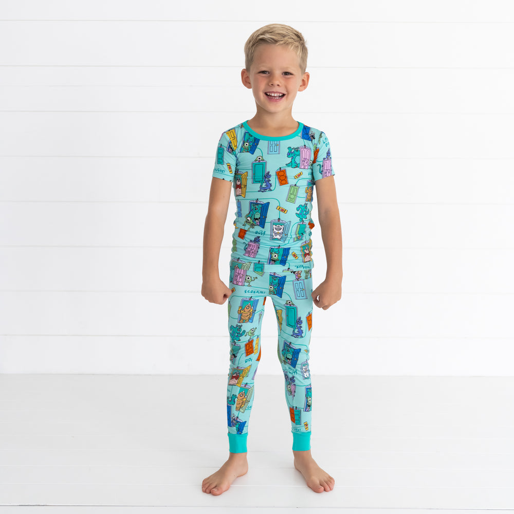 Smiling boy wearing the Disney Monsters, Inc. Scream Team Short Sleeve Two-Piece Pajama Set