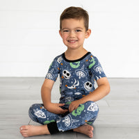 Child sitting while wearing the disney-jack-crew-two-piece-short-sleeve-pajama-set