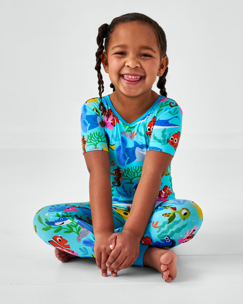 Sitting child wearing the Disney Nemo's Reef Two-Piece Short Sleeve Pajama Set