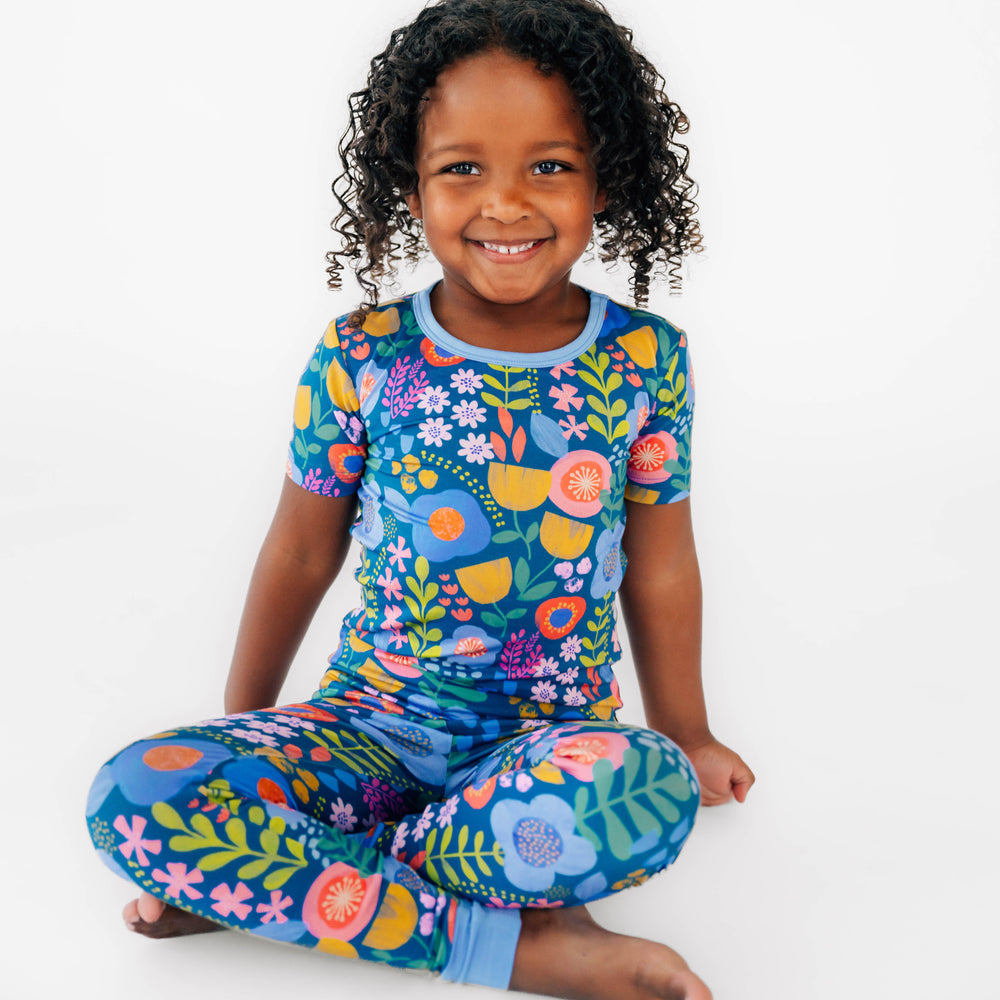 Girl sitting while wearing the Folk Floral Two-Piece Short Sleeve Pajama Set