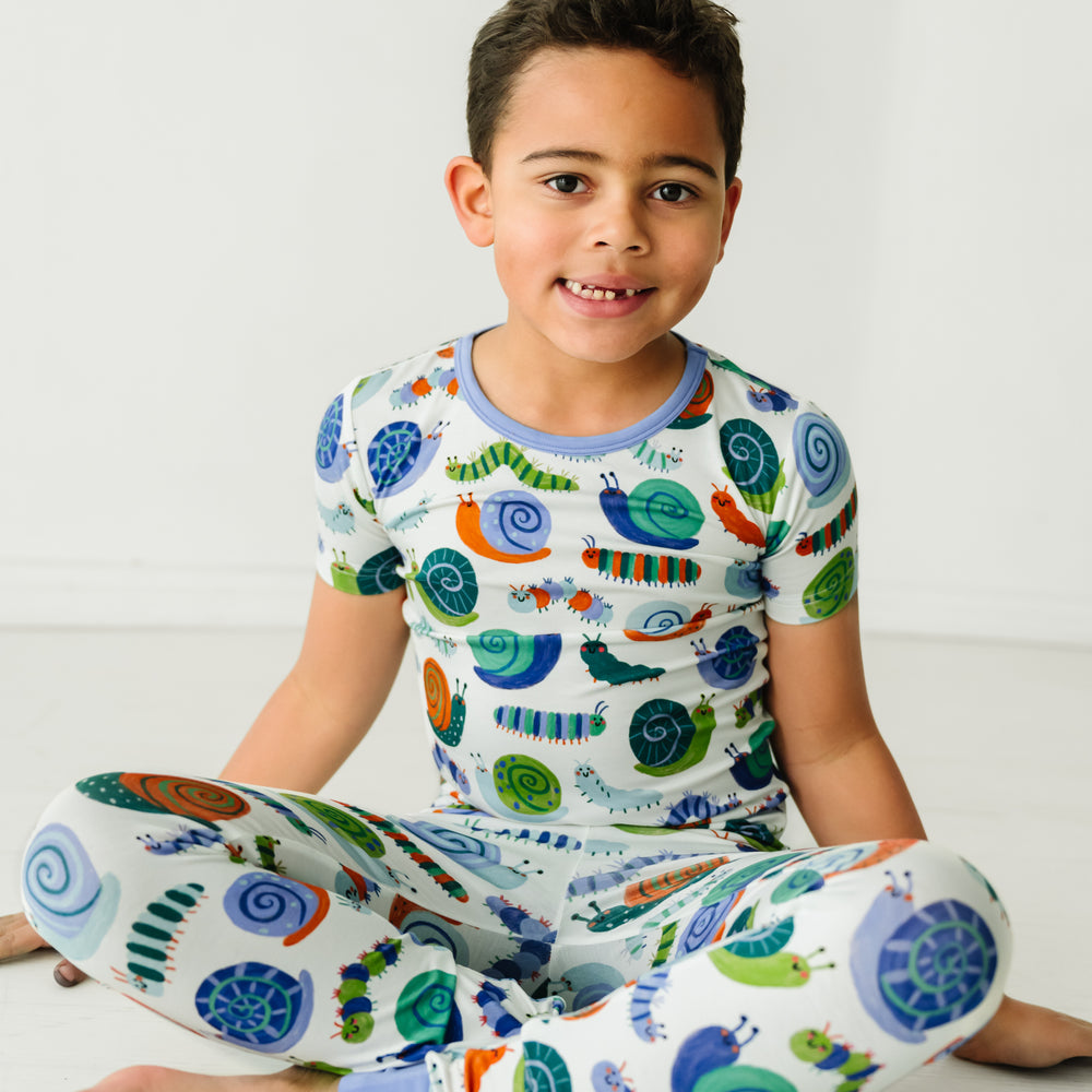Child sitting on the ground wearing an Inchin' Along two-piece short sleeve pajama set