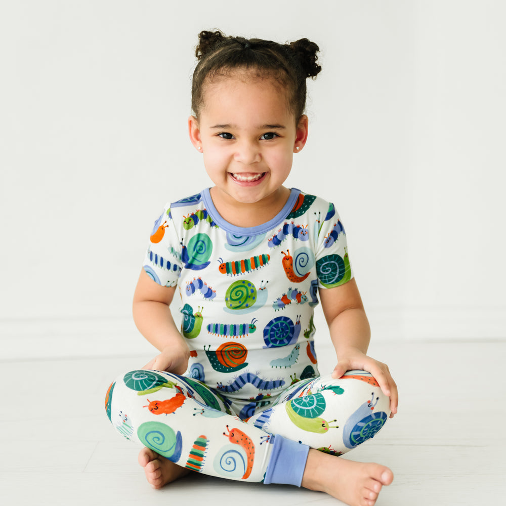 Alternate image of a child sitting on the ground wearing an Inchin' Along two-piece short sleeve pajama set