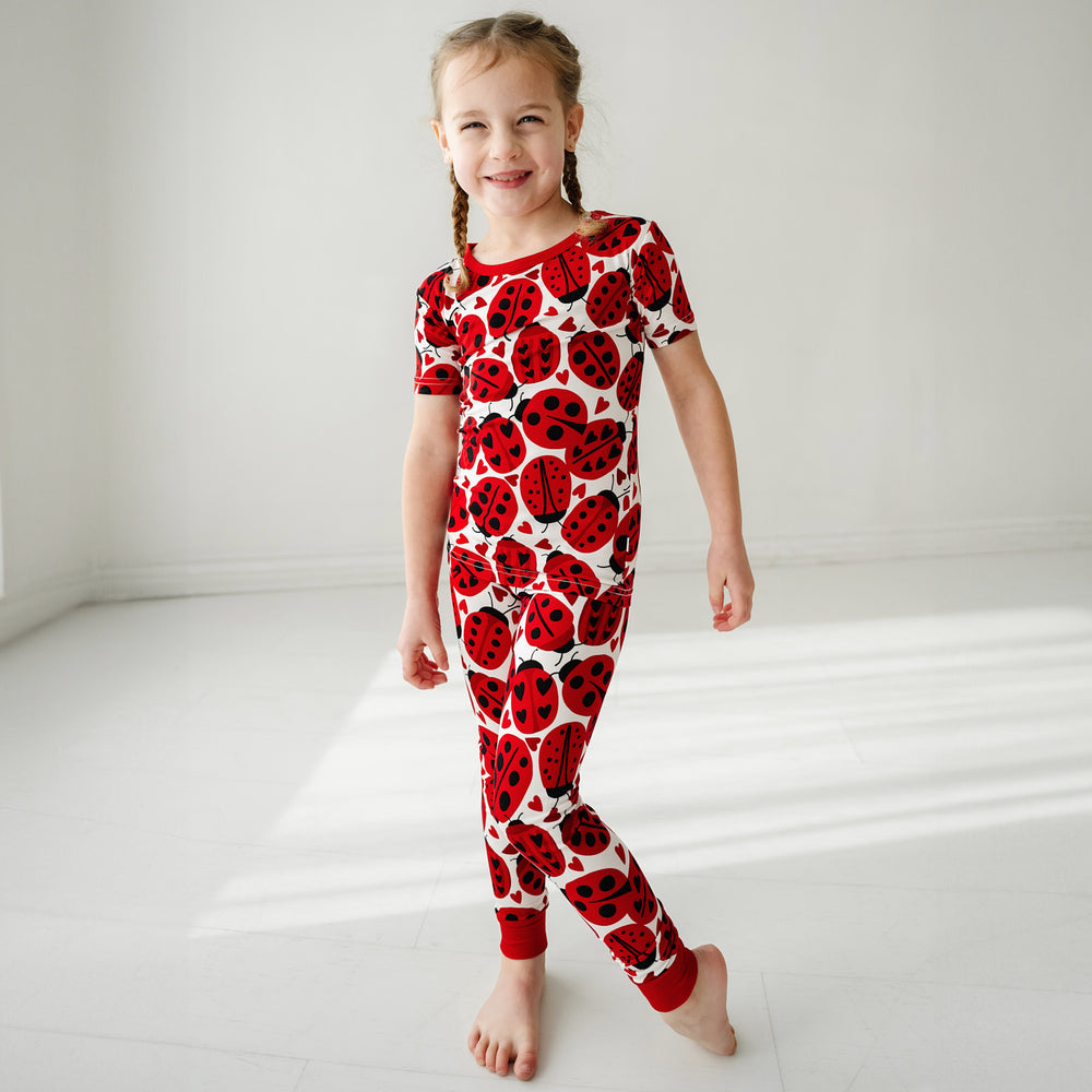 Click to see full screen - Child wearing a Love Bug printed two-piece short sleeve pajama set