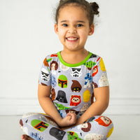 Child sitting on the ground wearing a Legends of the Galaxy two-piece short sleeve pajama set
