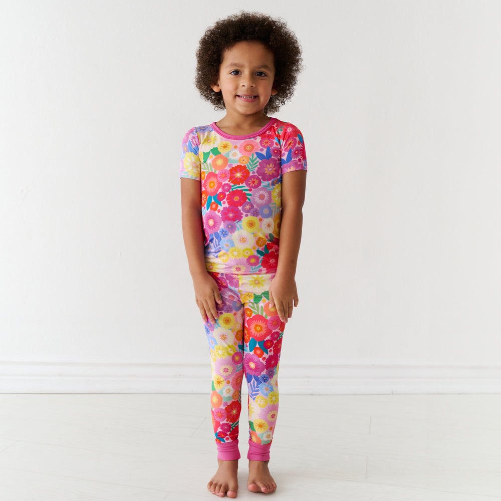 Child wearing a Rainbow Blooms two-piece short sleeve pajama set