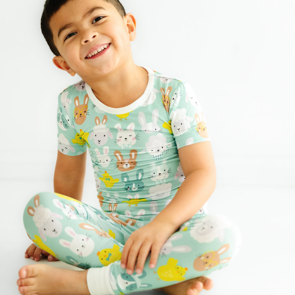 Click to see full screen - child sitting wearing a Aqua Pastel Parade two piece short sleeve pajama set