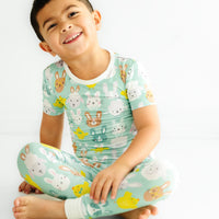 child sitting wearing a Aqua Pastel Parade two piece short sleeve pajama set