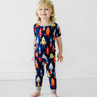Alternate image of a child posing wearing a Navy Space Explorer two piece short sleeve pajama set