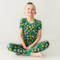 Child sitting wearing a Lucky printed two piece short sleeve pajama set
