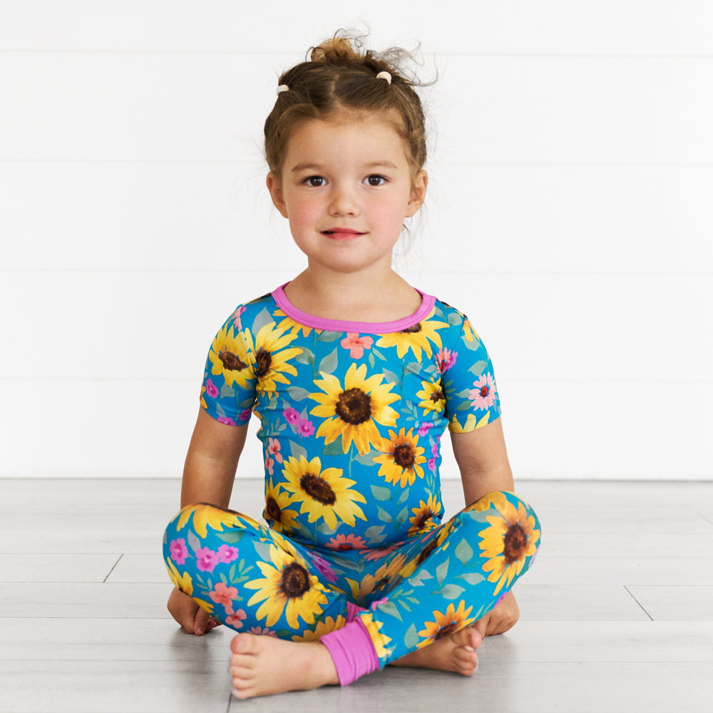 Girl sitting while wearing the Sunflower Fields Two-Piece Short Sleeve Pajama Set