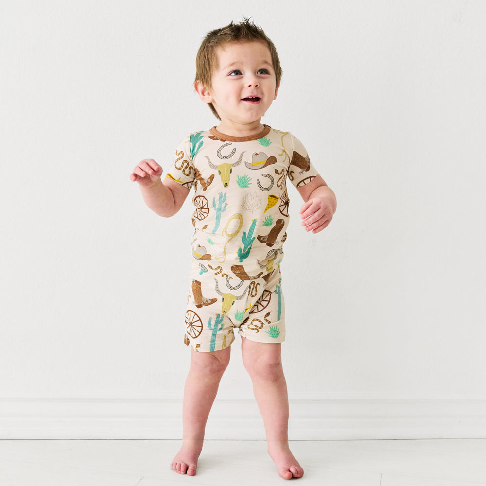 child wearing a Caramel Ready to Rodeo two piece short sleeve and shorts pajama sets