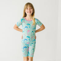 Child wearing a Dolphin Dance two-piece short sleeve & shorts pajama set