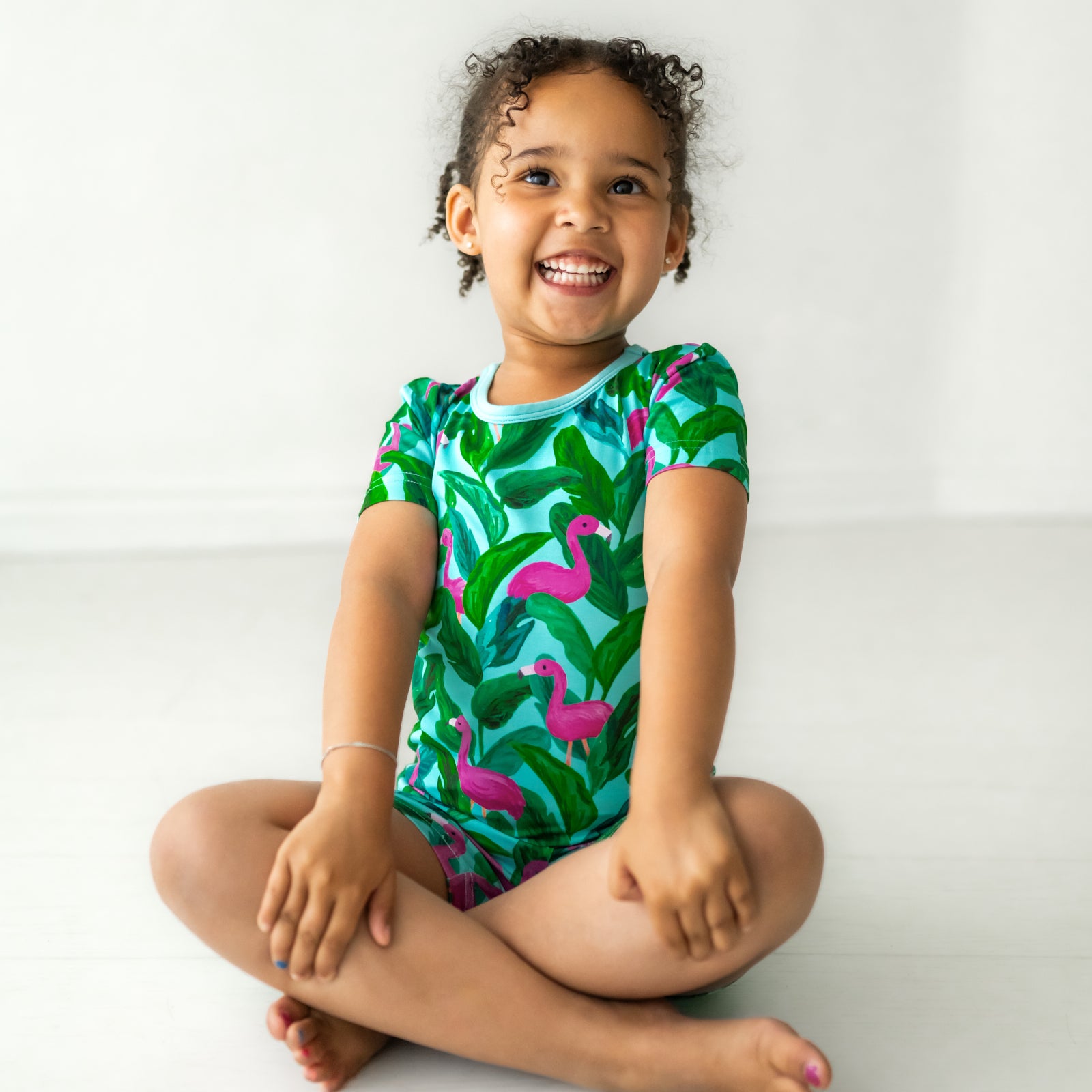 Child sitting posing wearing a Palm Springs two piece shorts and short sleeve pajama set