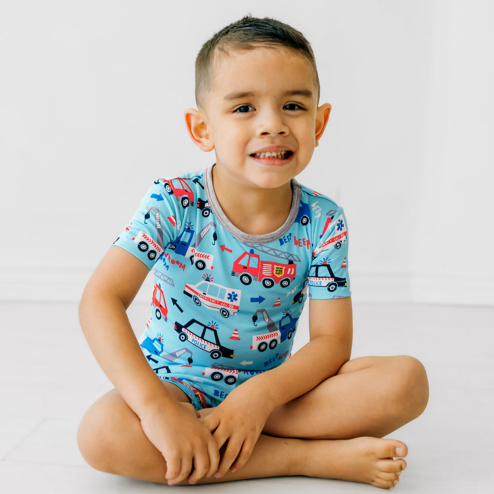Child sitting wearing a To The Rescue two piece short and short sleeve pj set