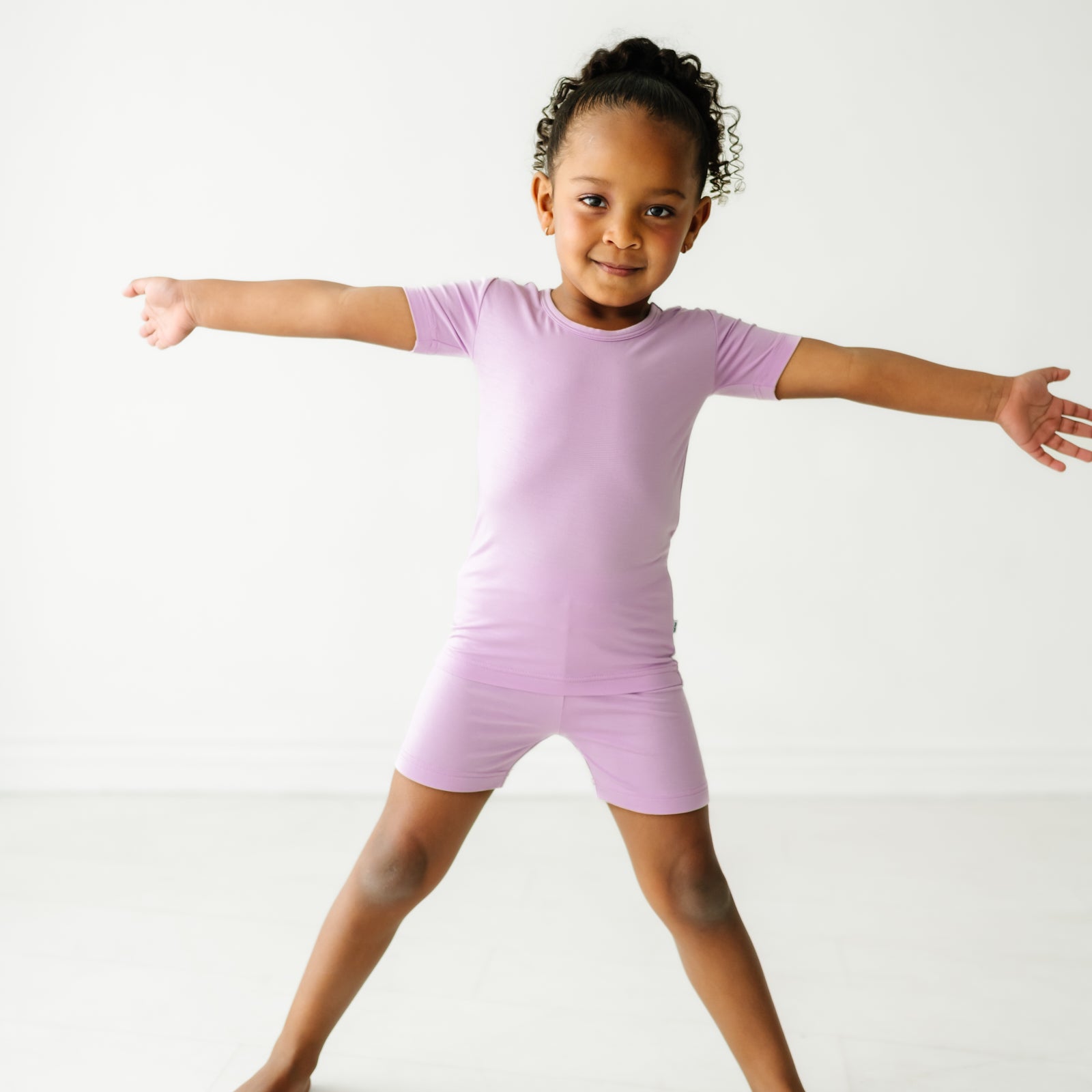 Child posing wearing a Light Orchid two piece shorts and short sleeve pajama set