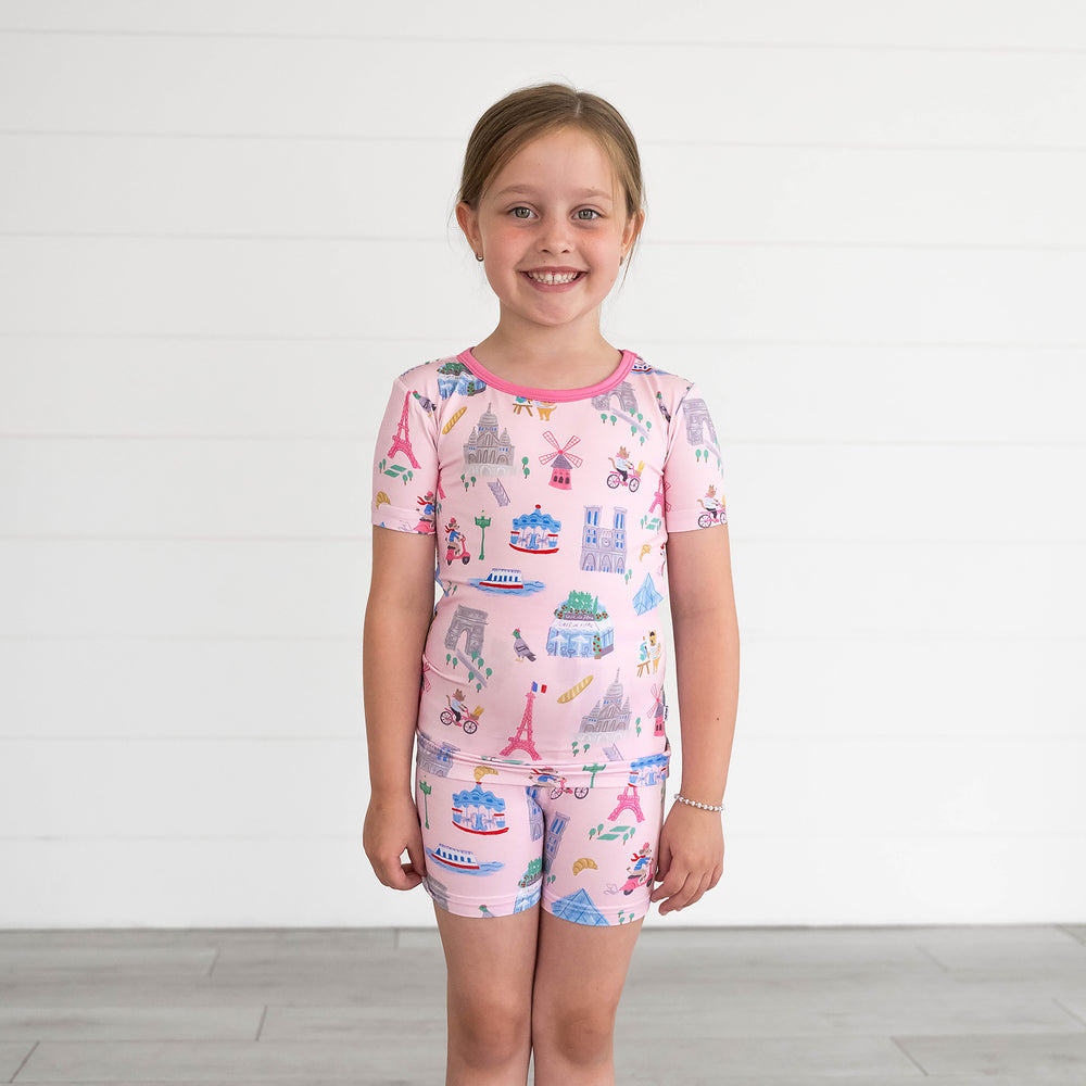 Child wearing the Pink Weekend in Paris Two-Piece Short Sleeve & Shorts Pajama Set