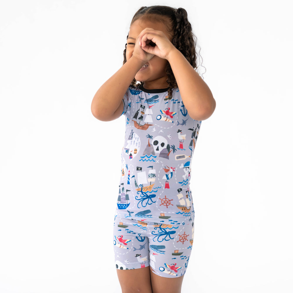 Girl posing while wearing the Pirate's Map Two-Piece Short Sleeve & Shorts Pajama Set