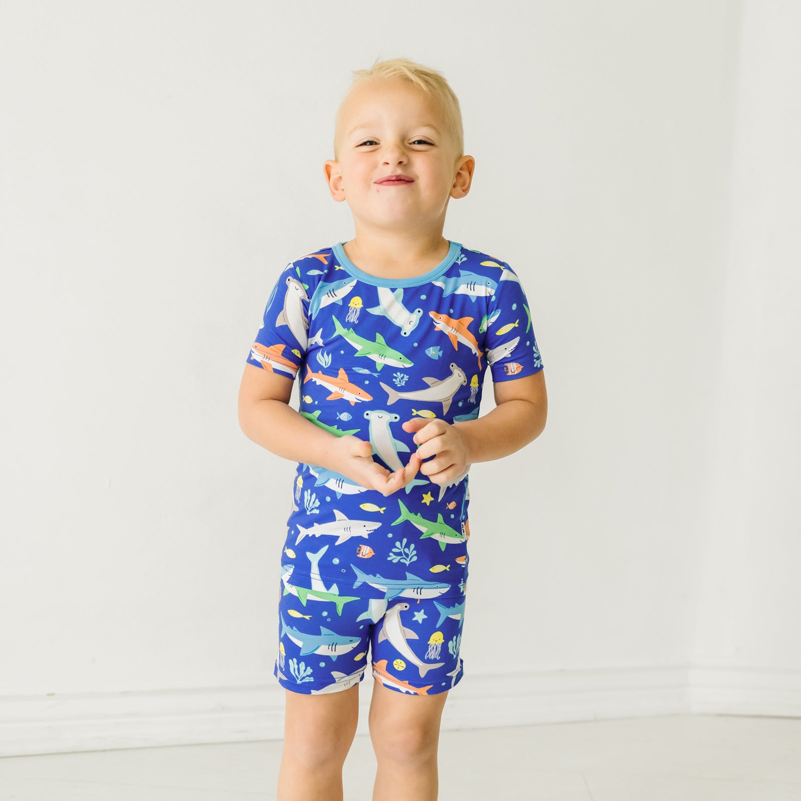 Child wearing a Rad Reef two-piece short sleeve & shorts pajama set