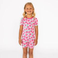 Girl standing while wearing the Sweet Strawberries Two-Piece Short Sleeve & Shorts Pajama Set