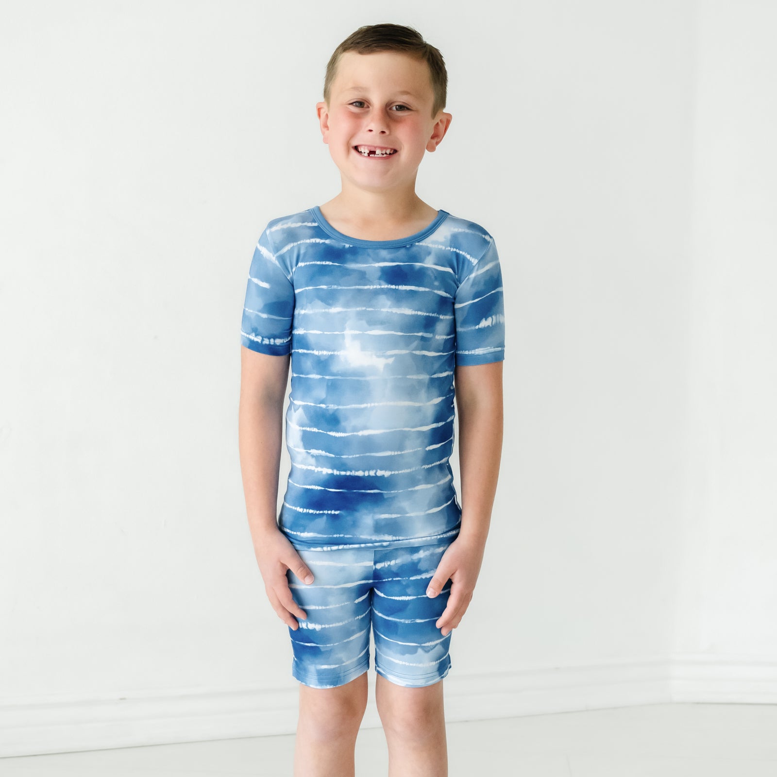 Child wearing a Blue Tie Dye Dreams two-piece short sleeve & shorts pajama set