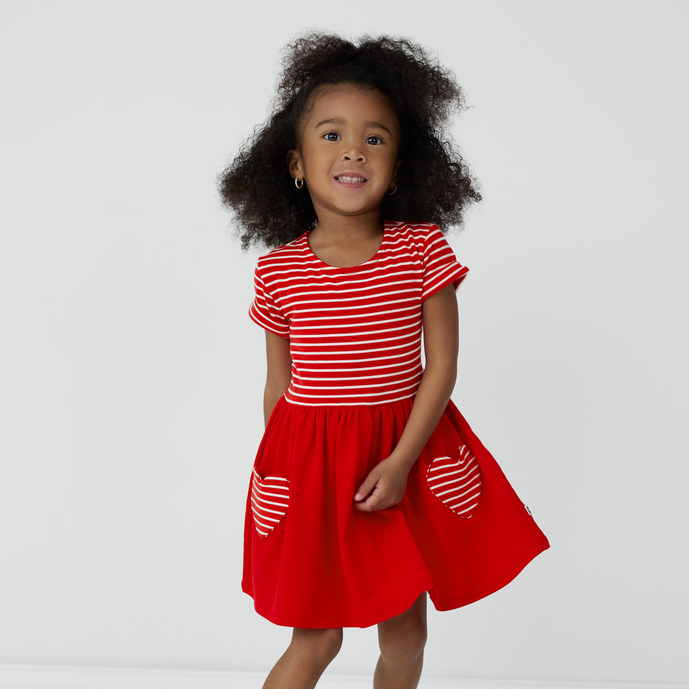 Child twirling around in a Candy Red Patch Pocket Dress