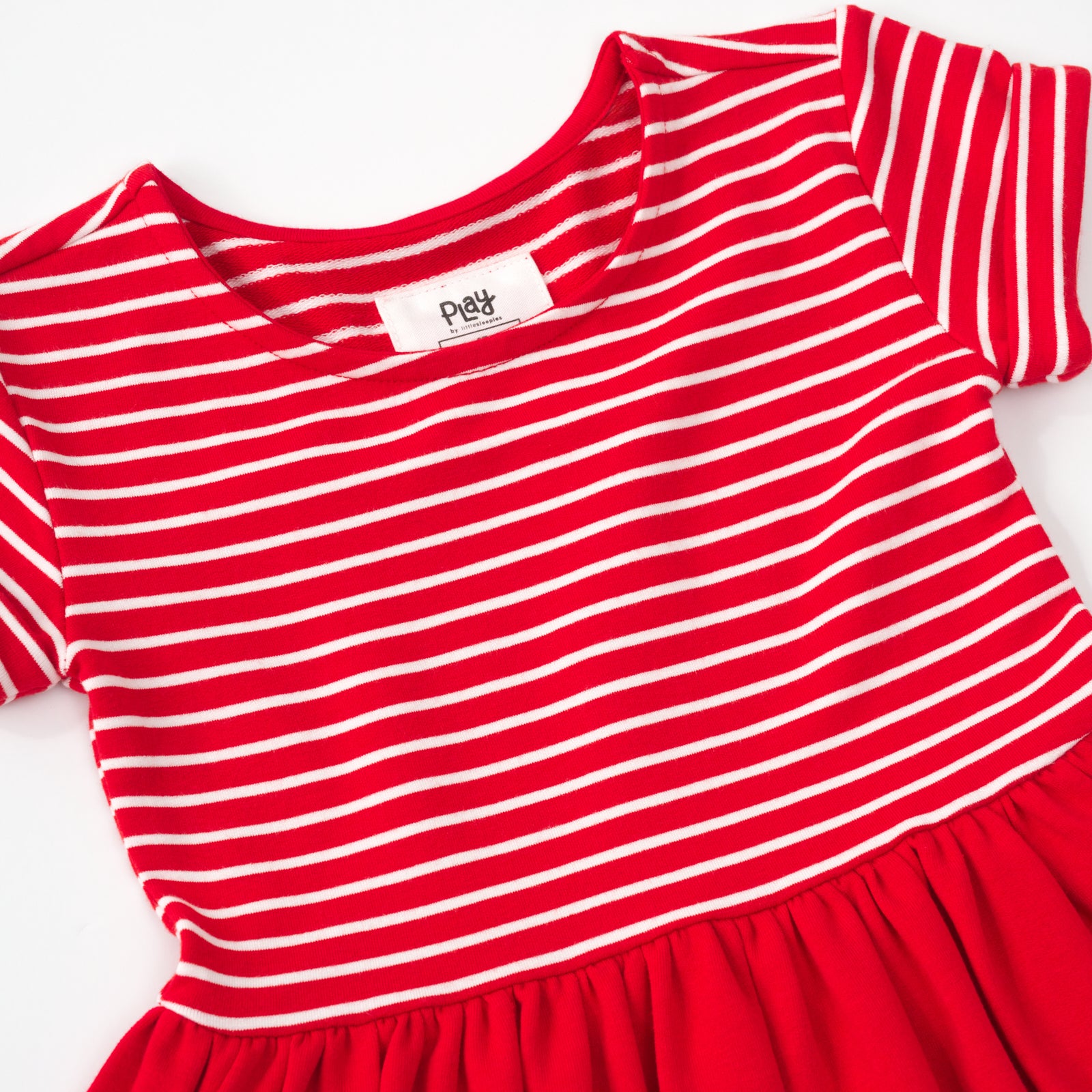 Close up flat lay of a candy red patch pocket dress with bloomer