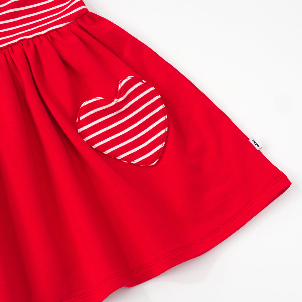 Close up of the pocket and bottom hem on a candy red patch pocket dress with bloomer